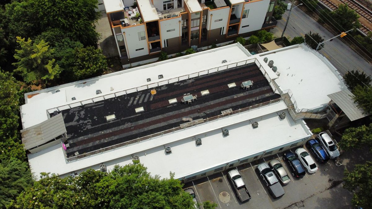 Aerial left-side view of finished commercial TPO roof with paver walkway