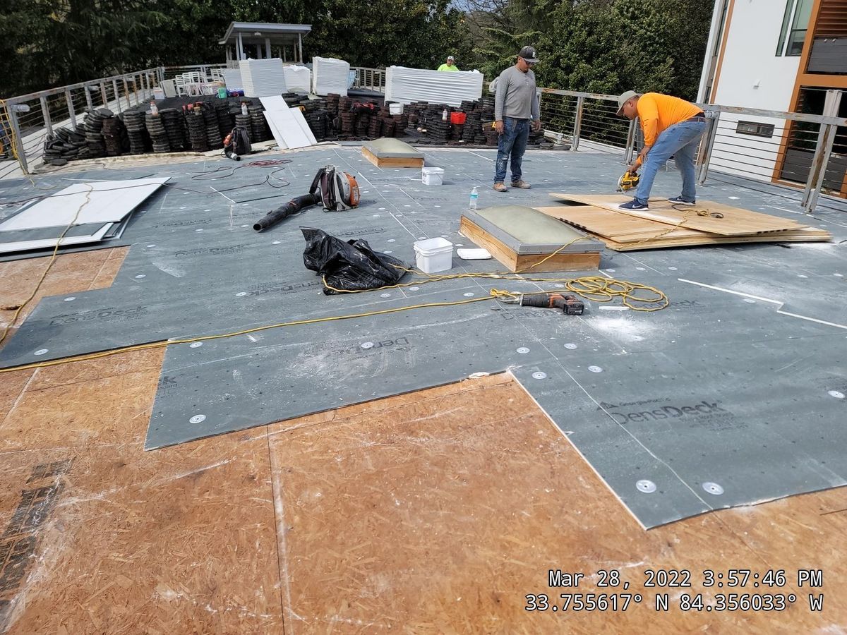 Aerial view of commercial TPO roof during paver system installation