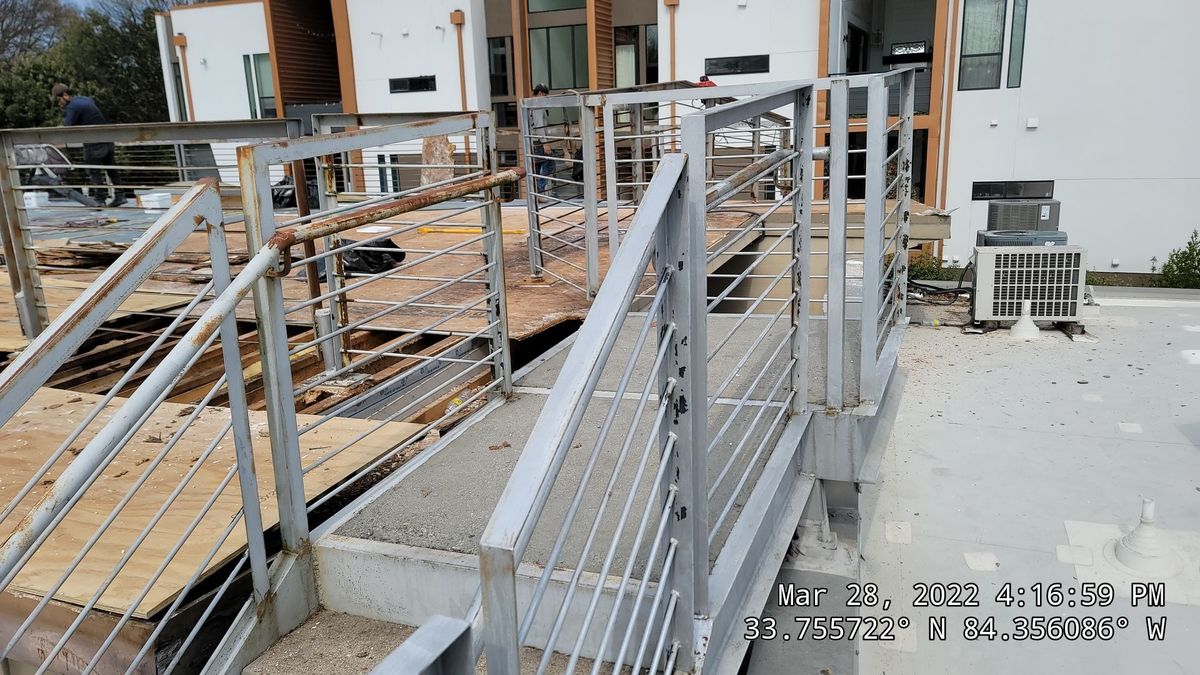 Commercial roofing crew installing TPO membrane and paver walkway system