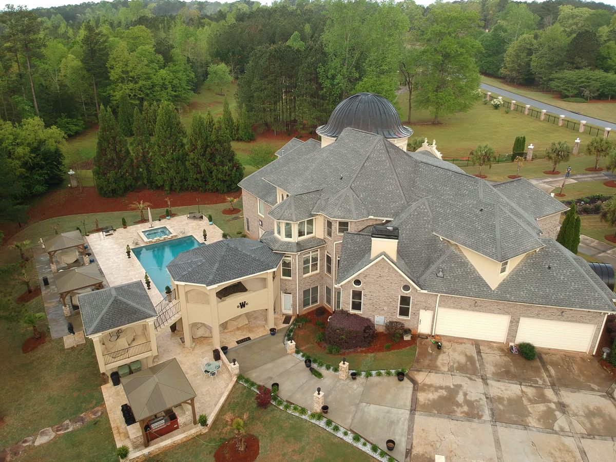Estate home roof condition before replacement — aging shingles and copper visible