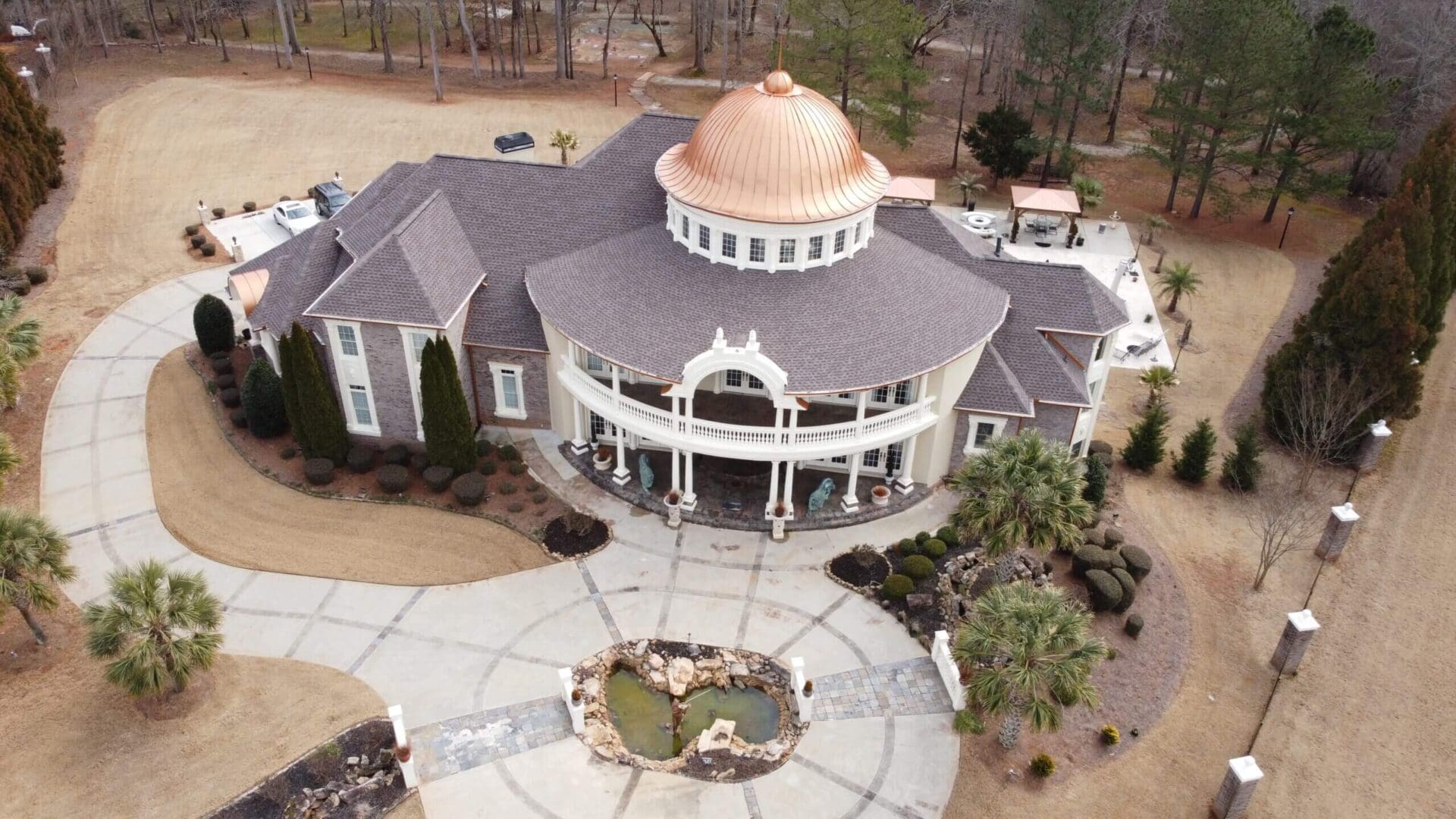 Aerial view of a large house with a copper dome.